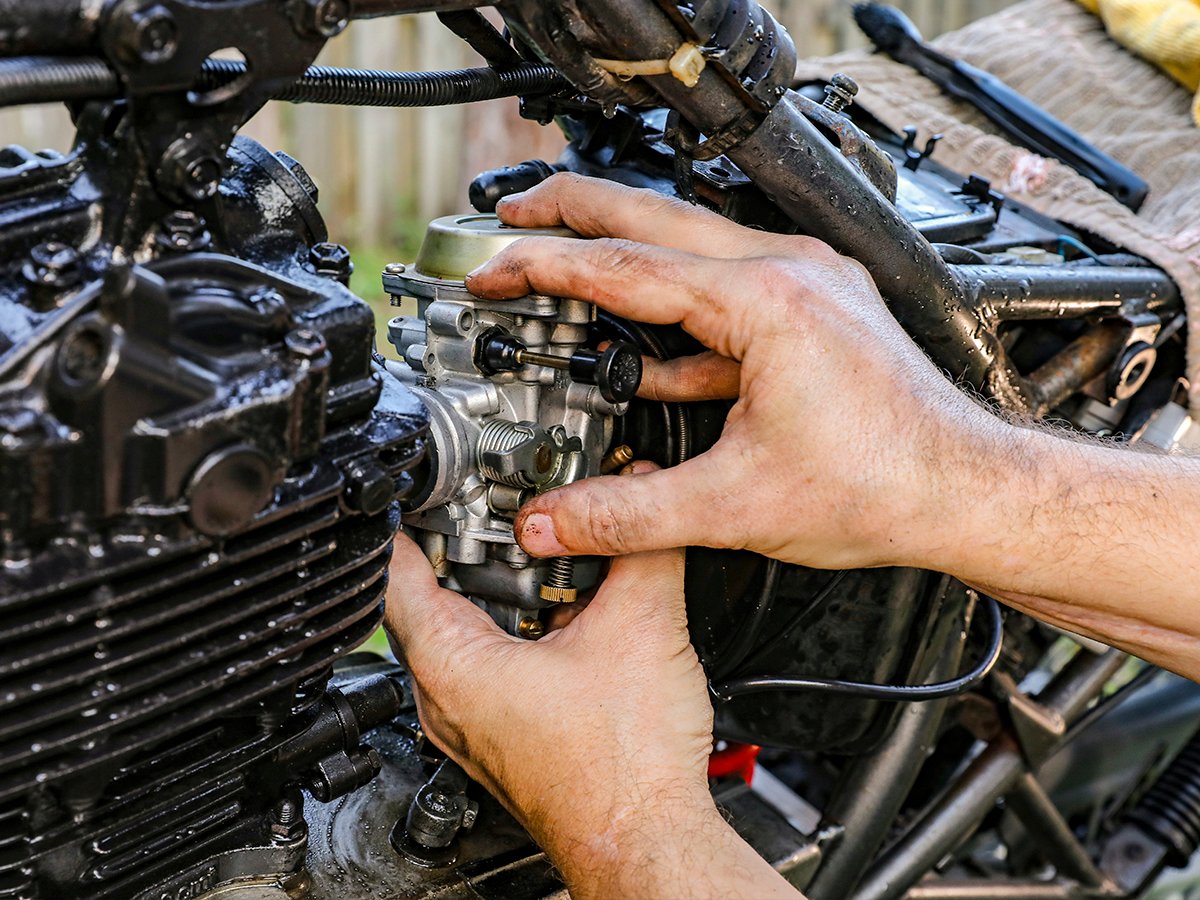 Mecânico trabalhando no motor de uma moto na oficina BS Moto Peças